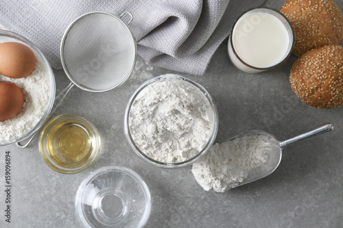 Composition with flour and ingredients for dough on light background