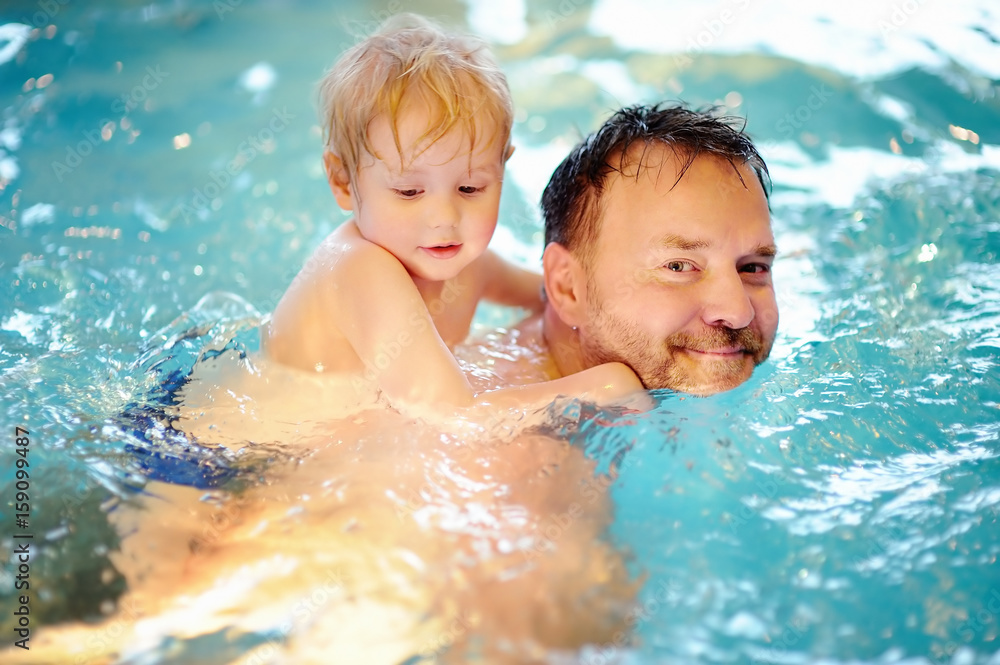 Happy little boy with his father in swimming pool Happy little boy with his father in swimming pool