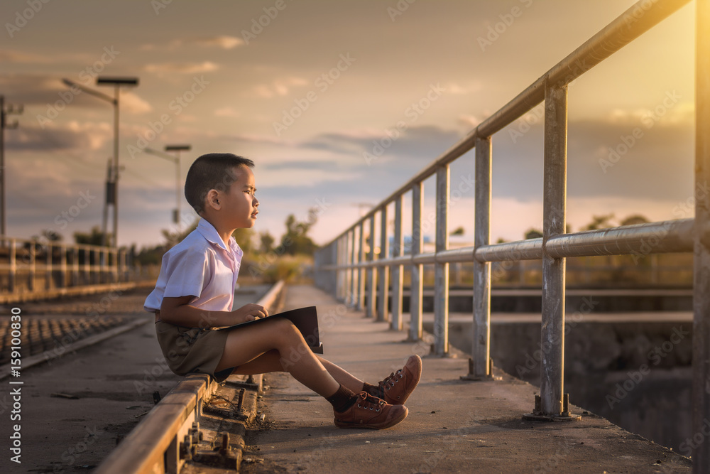 Boy student reading at the bridge at sunset,dream concept. Boy student reading at the bridge at sunset,dream concept.