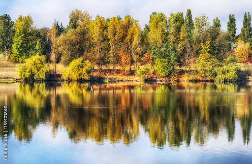 Obraz premium reflection. On the bank of the autumn river