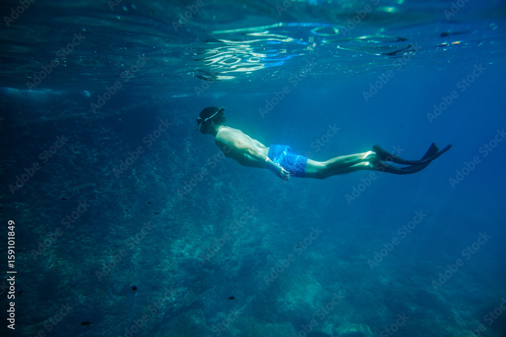 man swim underwater in snorkel