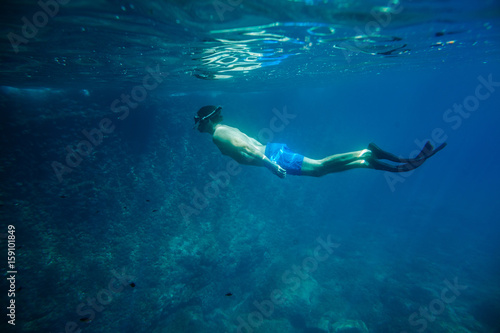 man swim underwater in snorkel