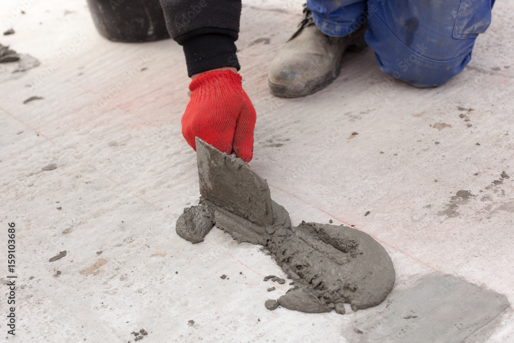 Worker use spatula for plastering a floor Worker use spatula for plastering a floor