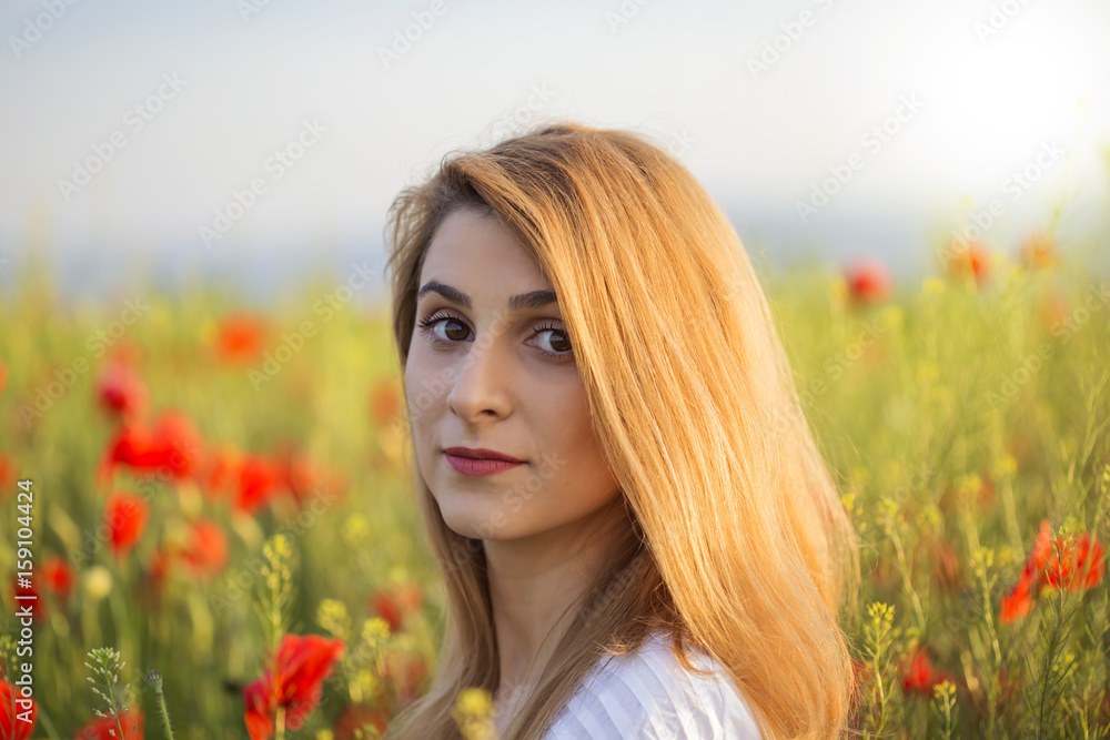 Portrait of blonde woman in field of poppies Portrait of blonde woman in field of poppies