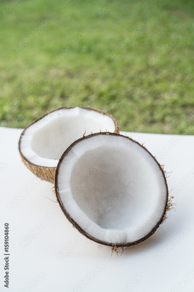 Closeup of coconuts on the white isolated over blurred grass background Closeup of coconuts on the white isolated over blurred grass background