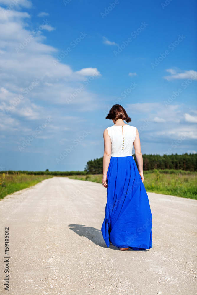 One woman walking along the road. The concept of lifestyle, travel. One woman walking along the road. The concept of lifestyle, travel.