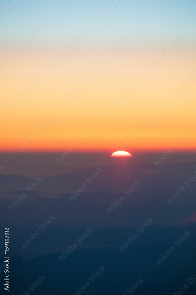 Orange sunset in the mountains. View from a height. Orange sunset in the mountains. View from a height.