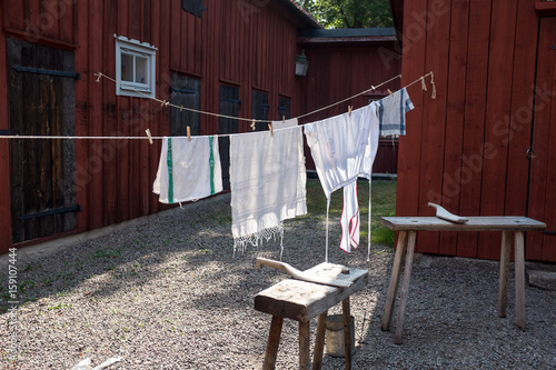 The laundry is hanging out to dry, in fine weather, on a lina outside the farm. The sun shines on the washboard and bleaching the white laundry nicely. photo