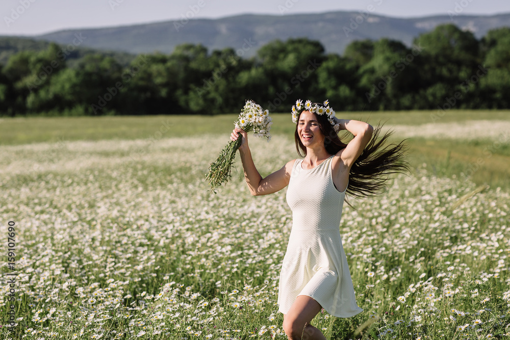 Woman enjoying a field of daisies, beautiful woman lying in a meadow of flowers, beautiful girl relaxing outdoors, having fun, holding plant, happy young lady and spring-green nature, harmony concept. Woman enjoying a field of daisies, beautiful woman lying in a meadow of flowers, beautiful girl relaxing outdoors, having fun, holding plant, happy young lady and spring-green nature, harmony concept.