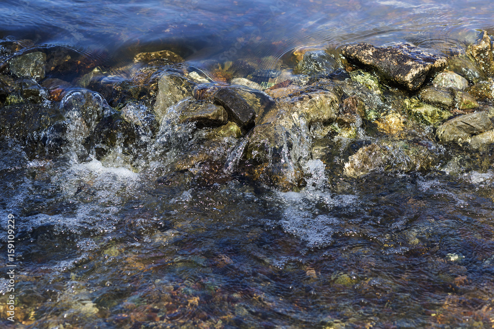Stream flowing over stones rough rocks Stream flowing over stones rough rocks