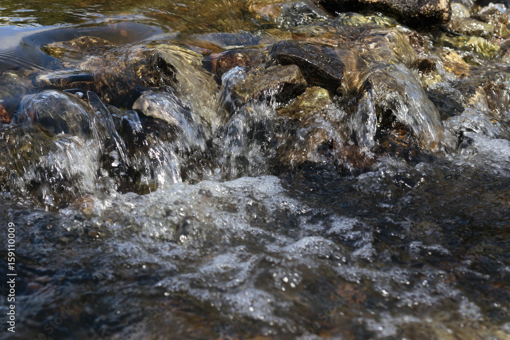 Stream flowing over stones rough rocks Stream flowing over stones rough rocks