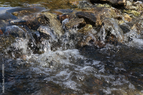 Stream flowing over stones rough rocks