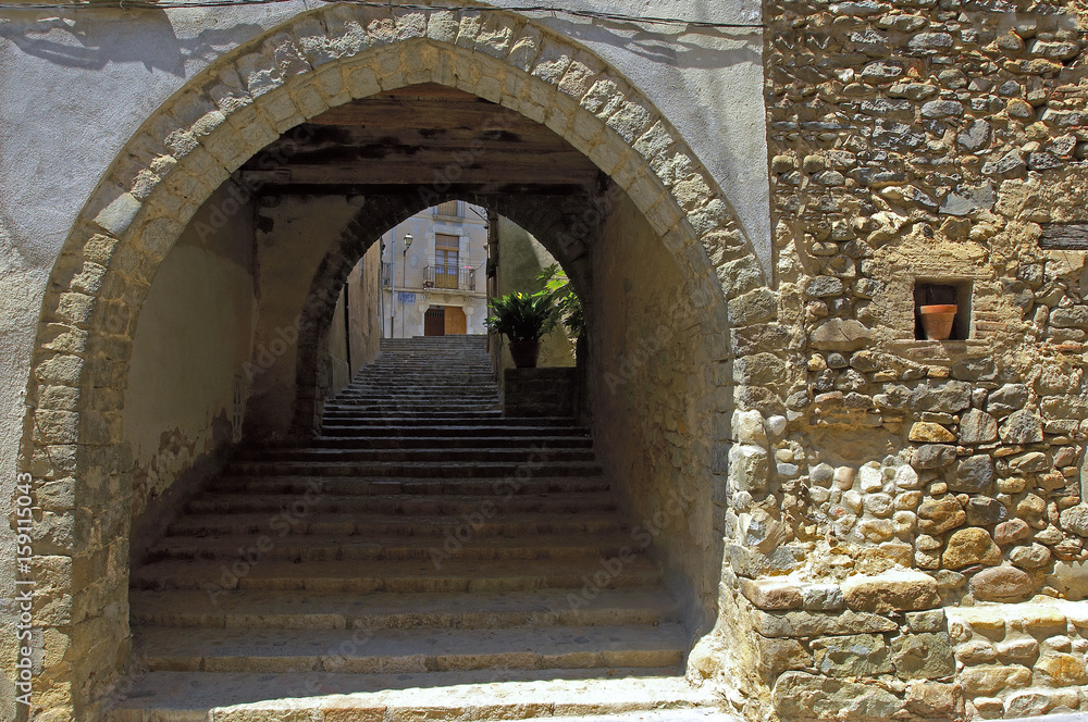 Angles pueblo de Girona calle principal con arcada de piedra muy antigua