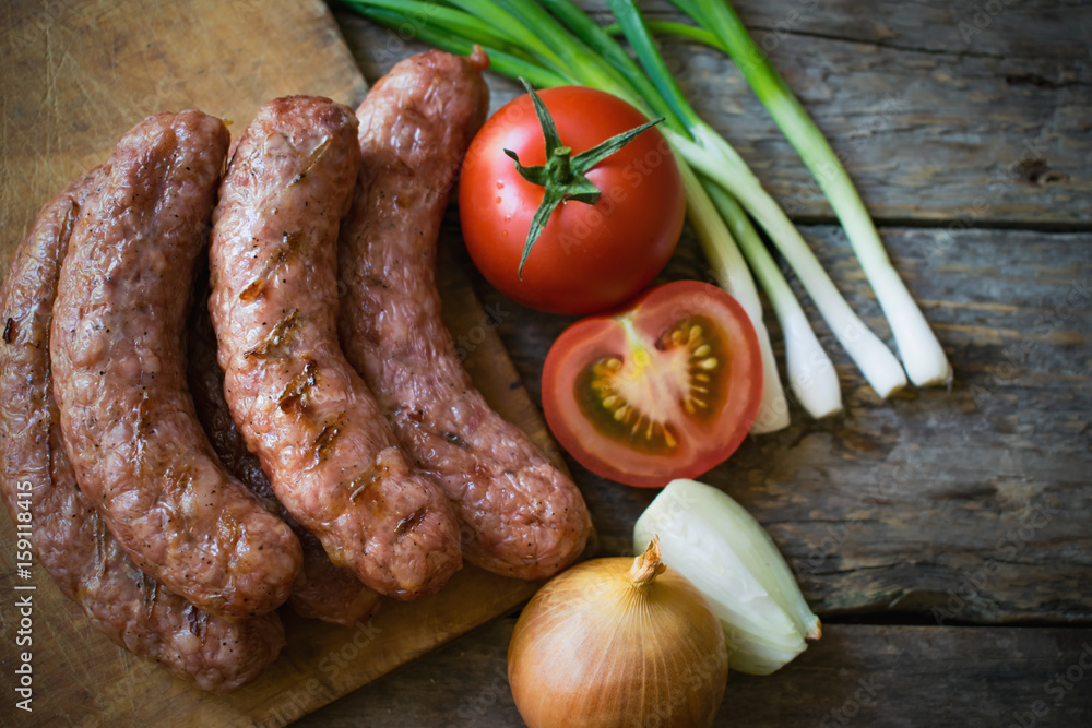 Sausages with vegetables on a wooden texture
Sausages with vegetables on a wooden texture