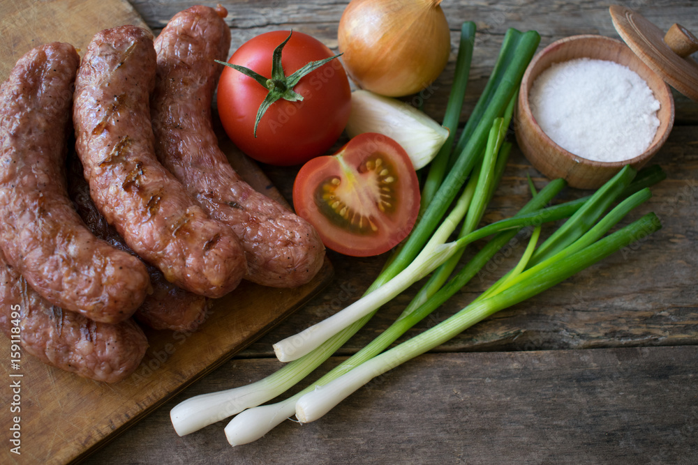 Sausages with vegetables on a wooden texture
Sausages with vegetables on a wooden texture