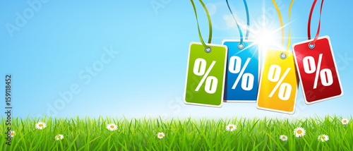 Bunte hängende Etiketten mit Prozent Zeichen mit Sonnenschein und Blumenwiese - Banner 