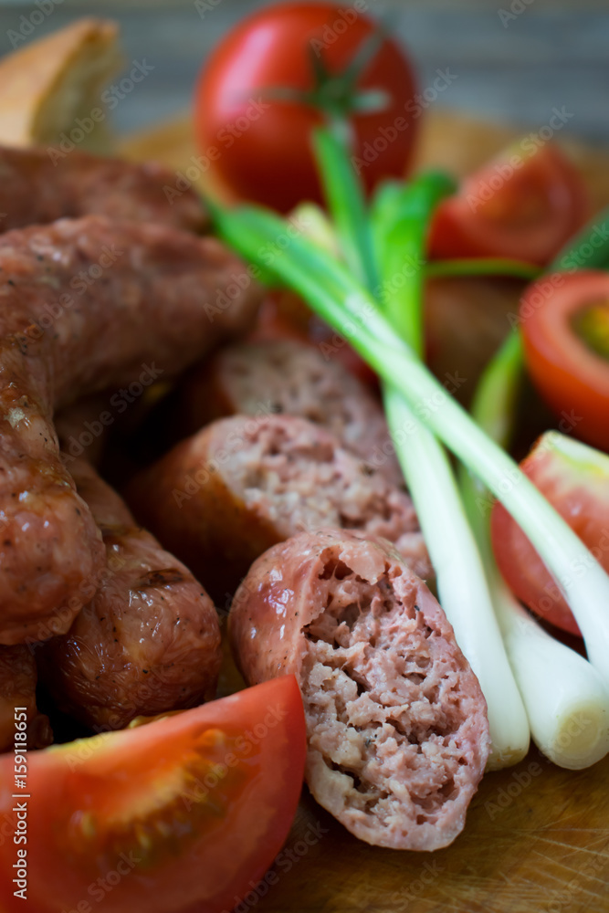 
Sausages with vegetables on a wooden texture