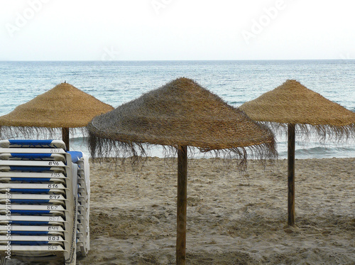 Tres sombrilas de brezo en la playa photo