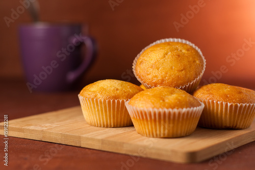 Fragrant cupcakes lie on a wooden table.
