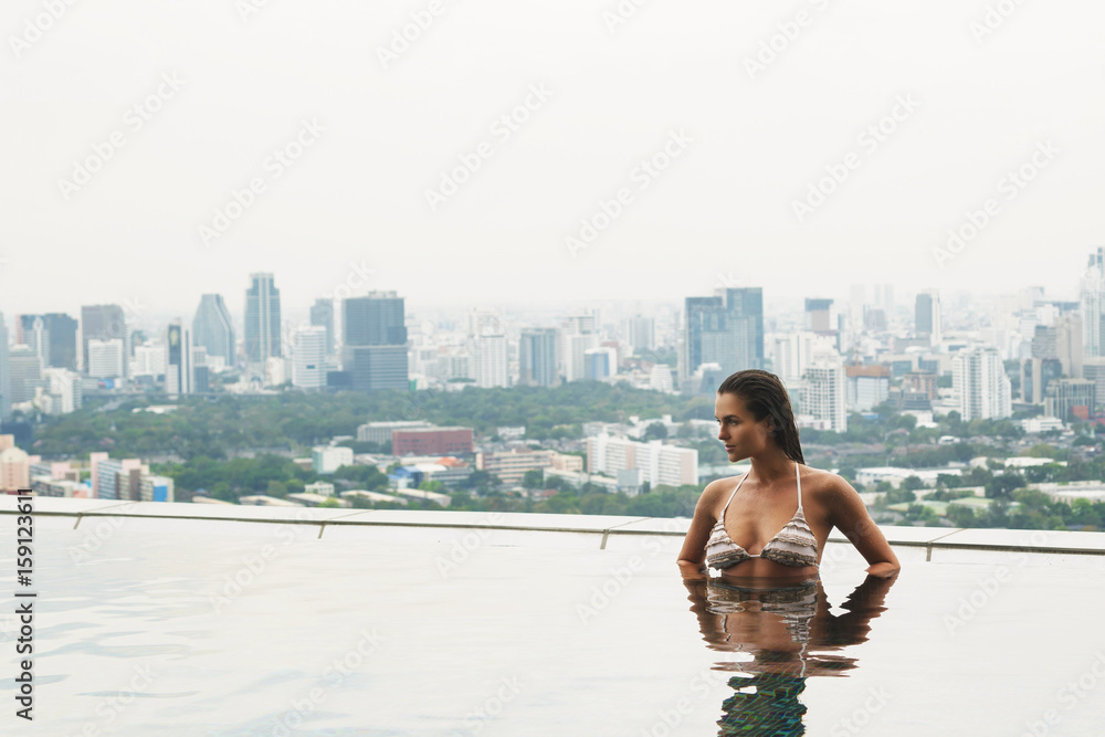 Woman relaxing on a rooftop pool