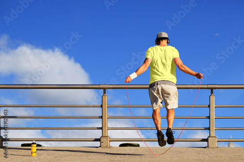 Morning exercises with skipping rope on the background of the sky