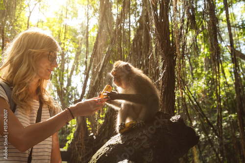 Photography Cute girl with monkey in forest.