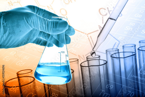 Flask in scientist hand with test tubes background 