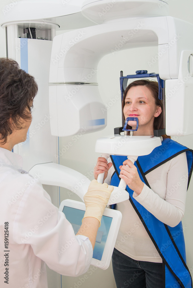 Dentist taking a panoramic digital X-ray of a patient s teeth Dentist taking a panoramic digital X-ray of a patient s teeth