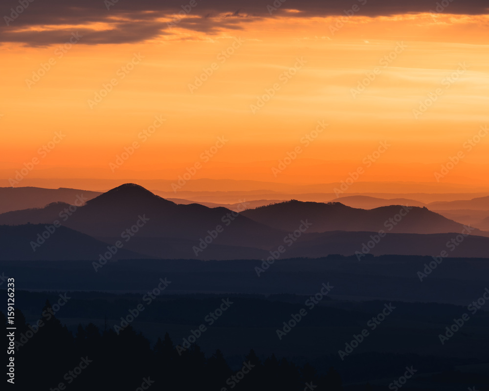 Tranquil landscape of mountains silhouettes during sunrise