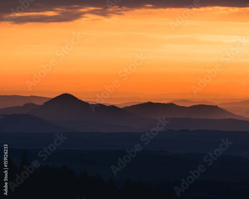 Tranquil landscape of mountains silhouettes during sunrise
