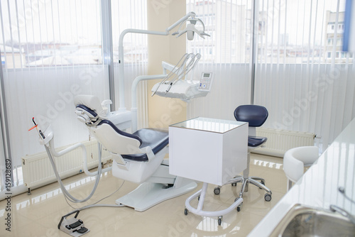 Modern dental clinic interior. Dental chair and other accessories.