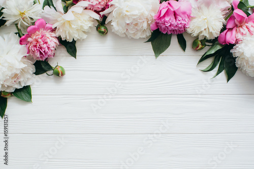 White and pink peonies on a wooden background.