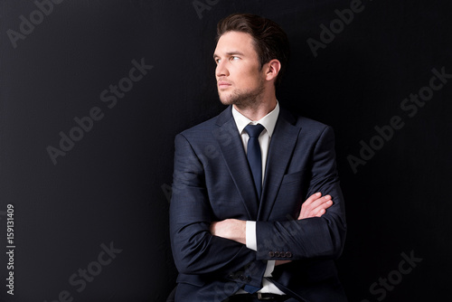 Pleasant businessman is posing with confidence