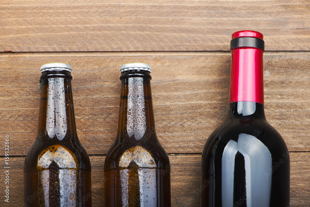 Top view of two beer bottles and a wine on wooden table. Top view of two beer bottles and a wine on wooden table.