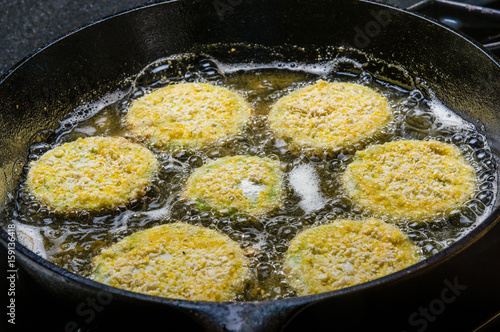 Slices of green tomato being fried