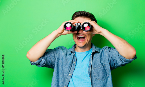 Young smiling man with binocular photo