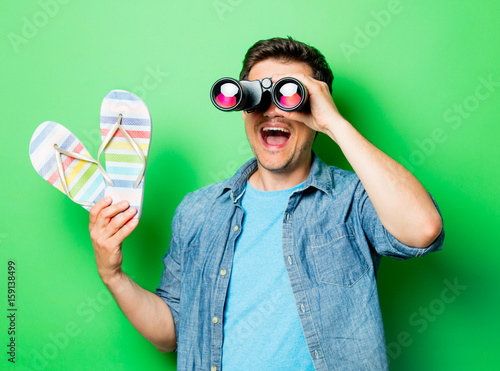 Young surprsied man with binocular photo