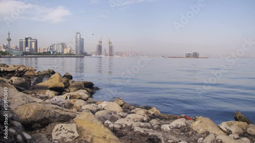 Embankment of Baku, Azerbaijan. The Caspian Sea, stones and skyscrapers. Calm on the dirty sea. photo