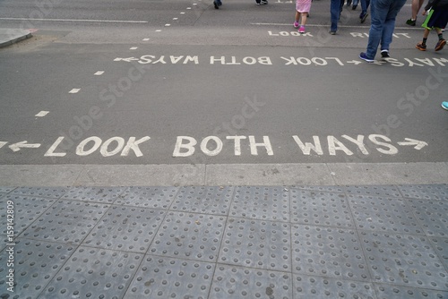 text look both ways in white letters on asphalt of street in London