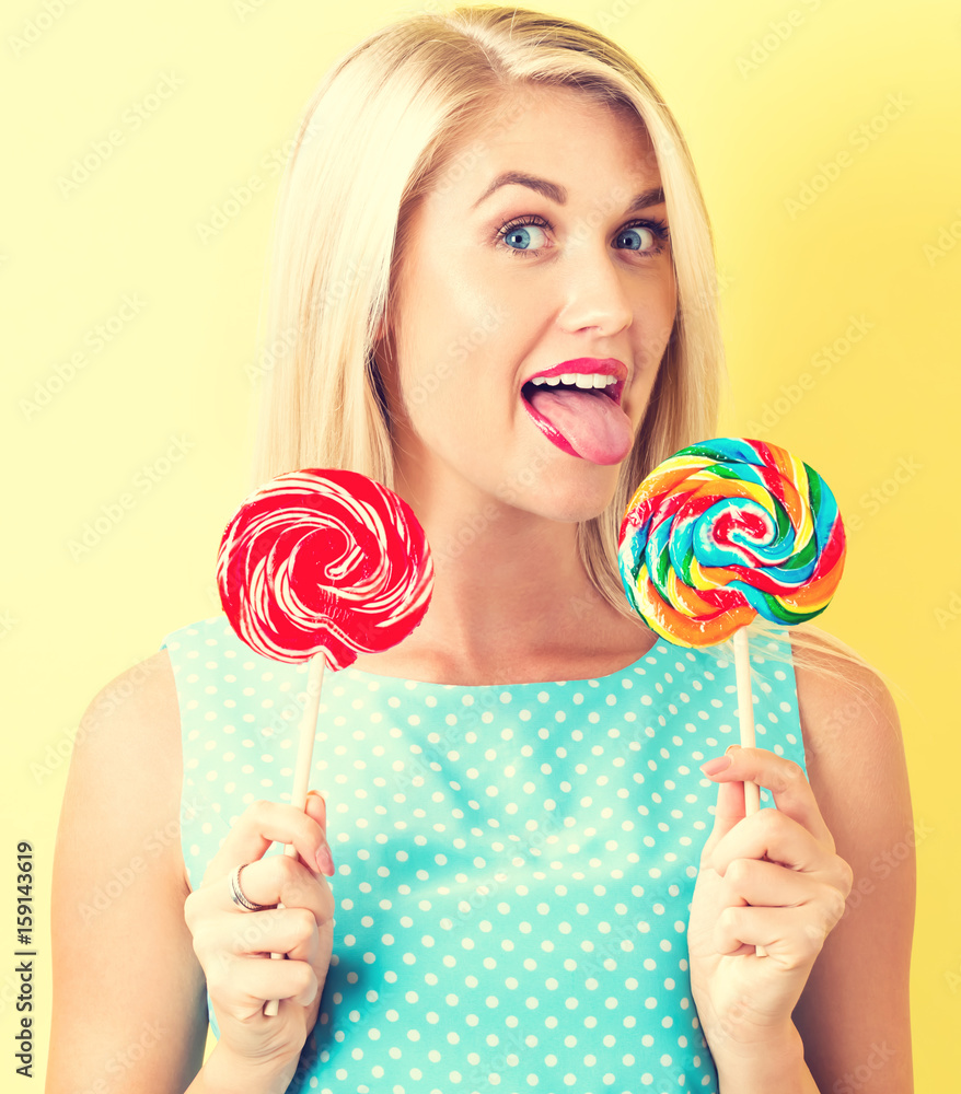Young woman holding lollipops