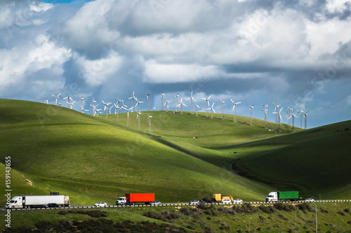 Wind turbines on a hillside, against the backdrop of cloud-filled blue sky in the Livermore, California wind farm