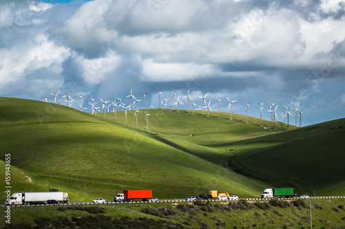 Wind turbines on a hillside, against the backdrop of cloud-filled blue sky in the Livermore, California wind farm photo