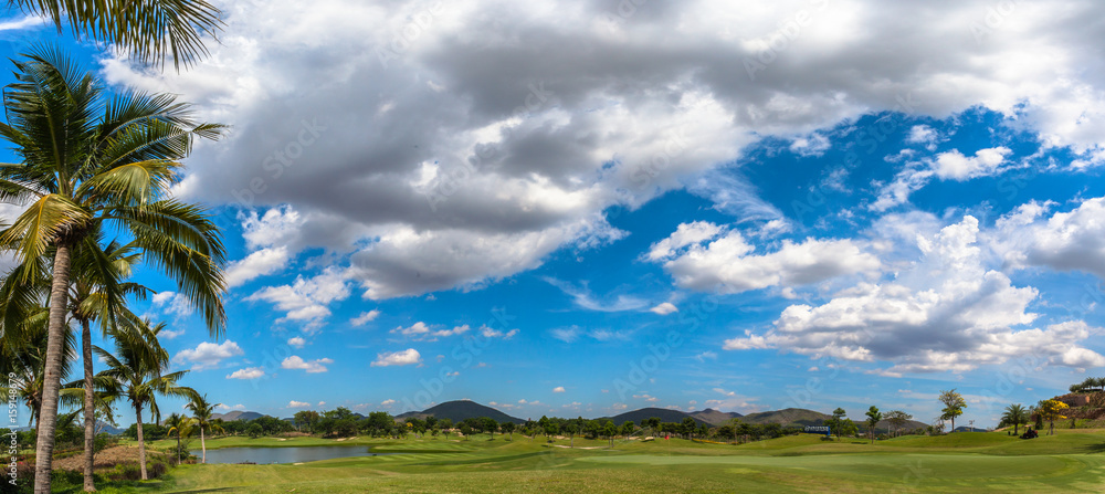 white clouds in blue sky above the golf field