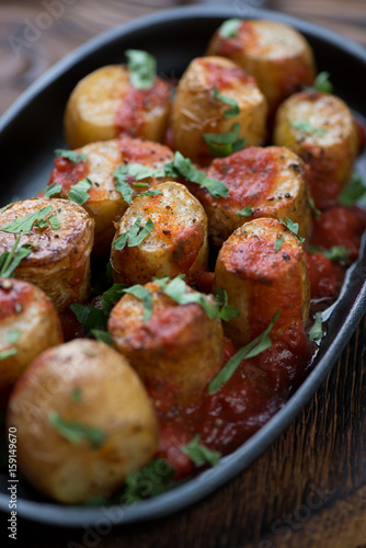 Close-up of whole baked potatoes cooked in sicilian style, selective focus, shallow depth of field
