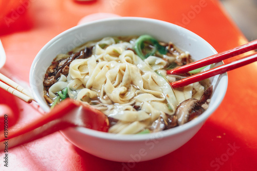 Ban Mian is a popular noodle dish, consisting of handmade noodles with flat egg served in soup or dried with vegetables, anchovy and fish or meat in Kuala Lumnpur, Malaysia.  photo