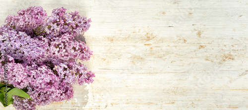 frame of lilac at the short side of the wooden background  top view with copy space