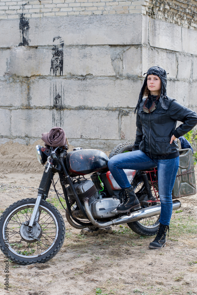 A post apocalyptic woman near motorcycle near the destroyed building