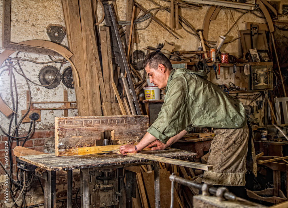 a man works on the machine with the wooden product a man works on the machine with the wooden product