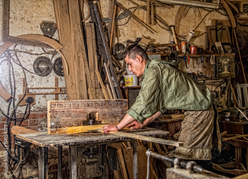 a man works on the machine with the wooden product