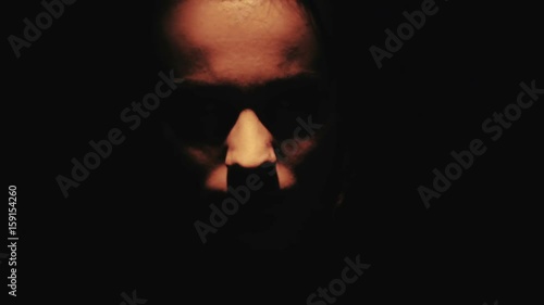 Scary face of a man in the dark close-up